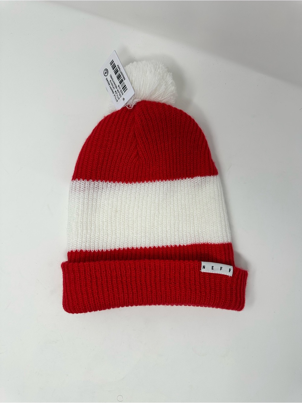 Red & white striped Neff beanie features a pom pom and a cuffed design